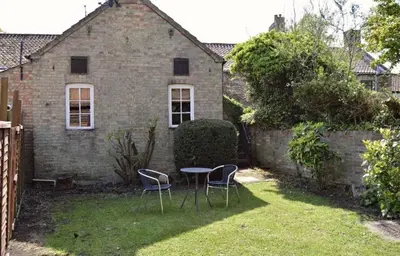 a yard with two chairs and a table in front of a house at The Chequers in Downham Market