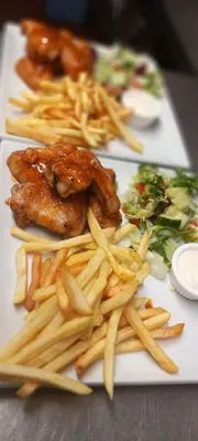 a plate of food with french fries and meat at The Chequers in Downham Market
