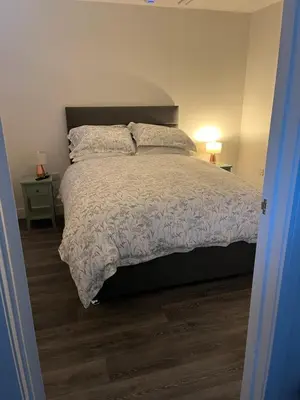 a bedroom with a large bed with a wooden floor at The Chequers in Downham Market