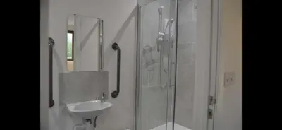 a bathroom with a shower and a sink and a mirror at The Chequers in Downham Market