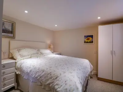 a bedroom with a bed and a dresser at The Cottage in Sudbury