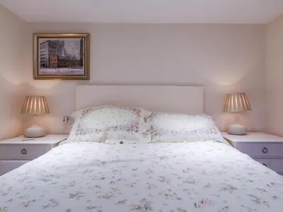a bedroom with a white bed with two night stands at The Cottage in Sudbury