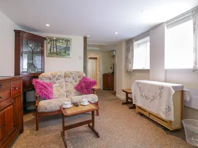a living room with a couch and a table at The Cottage in Sudbury