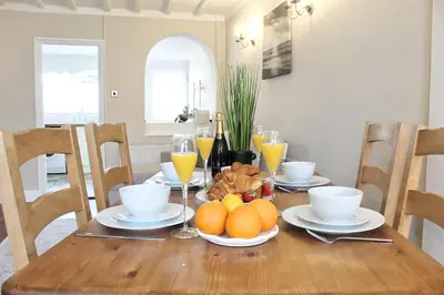 a dining room table with oranges and glasses of orange juice at Cosy Cottage in Mersea - Walking distance to beach and town in West Mersea