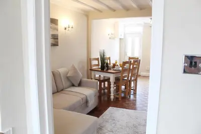 a living room with a couch and a table at Cosy Cottage in Mersea - Walking distance to beach and town in West Mersea
