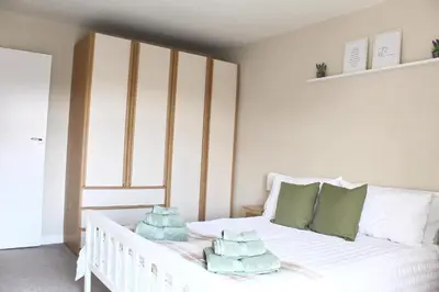a bedroom with a white bed with towels on it at Cosy Cottage in Mersea - Walking distance to beach and town in West Mersea