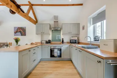 a kitchen with white cabinets and a counter top at The Old Dairy & The Old Stables in Thetford