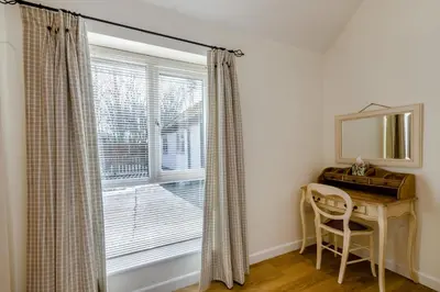 a room with a window with a desk and a mirror at The Old Dairy & The Old Stables in Thetford
