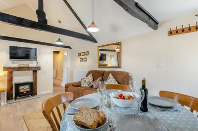 a dining room with a table and a fireplace at The Old Dairy & The Old Stables in Thetford