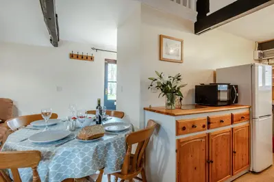 a dining room with a table and a refrigerator at The Old Dairy & The Old Stables in Thetford
