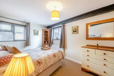 a bedroom with a bed and a dresser and a mirror at The Old Dairy & The Old Stables in Thetford