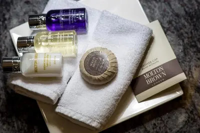 a bottle of lotion and a bottle of lipstick on a towel at Bedford Lodge Hotel & Spa in Newmarket