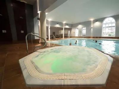 a large hot tub with people in a swimming pool at Bedford Lodge Hotel & Spa in Newmarket