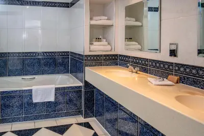 a bathroom with a tub and a sink at Best Western Heath Court Hotel in Newmarket