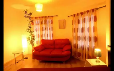 a living room with a red chair and a table at Cambridge city centre accommodations in Cambridge