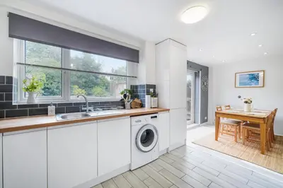 a kitchen with a sink and a washing machine at Kingside Residence Stevenage in Stevenage