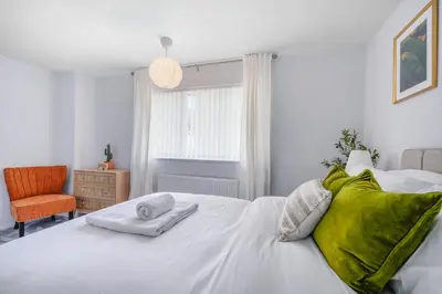 a bedroom with a white bed with green pillows at Kingside Residence Stevenage in Stevenage