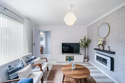 a living room with a couch and a tv at Kingside Residence Stevenage in Stevenage