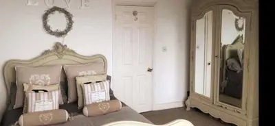 a bedroom with a bed with pillows and a mirror at Stunning sea views from rooms and terraces in Leigh-on-Sea