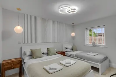 a white room with two beds and a couch at The old Stables in Wymondham