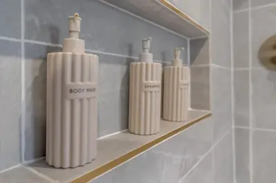 a shelf with three white candles on it in a bathroom at The old Stables in Wymondham