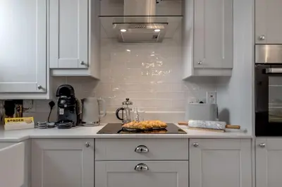 a kitchen with white cabinets and a plate of food at The old Stables in Wymondham
