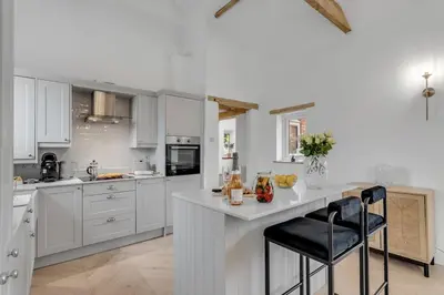 a kitchen with white cabinets and a white counter top at The old Stables in Wymondham