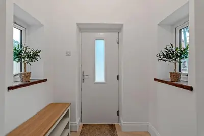 a hallway with a white door and two windows at The old Stables in Wymondham