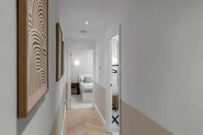a hallway with white walls and a room with a bed at The old Stables in Wymondham