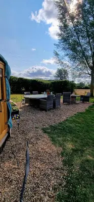 a backyard with chairs and a table and a bench at The Isla Yurt in Colchester