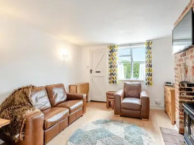 a living room with a couch and a chair at Meadowland Holiday Cottage in Eye