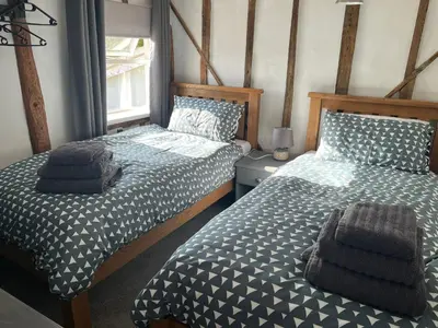 a bedroom with two twin beds and a window at Meadowland Holiday Cottage in Eye
