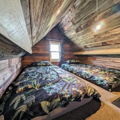 a bedroom with two beds in a log cabin at Lake View lodges The Lavenham in Long Melford