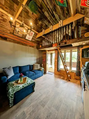 a living room with a blue couch and a loft at Lake View lodges The Lavenham in Long Melford