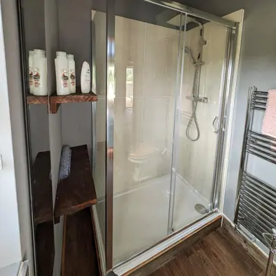 a shower stall with a glass door in a bathroom at Lake View lodges The Lavenham in Long Melford
