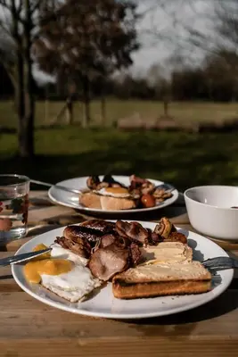 two plates of food on a wooden table at Honeywood Farm Cabins in Woodham Ferrers