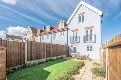 a white house with a fence and a yard at The Salty Dog, Aldeburgh in Aldeburgh