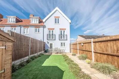 a white house with a fence and a yard at The Salty Dog, Aldeburgh in Aldeburgh