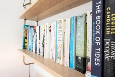 a row of books on a wooden shelf at The Salty Dog, Aldeburgh in Aldeburgh