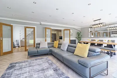 a living room with a blue couch and a table at LMV Property - Modern Luxury Family Home in Theydon Bois With London Skyline Views in Theydon Bois