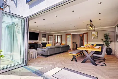 a living room with a couch and a table at LMV Property - Modern Luxury Family Home in Theydon Bois With London Skyline Views in Theydon Bois