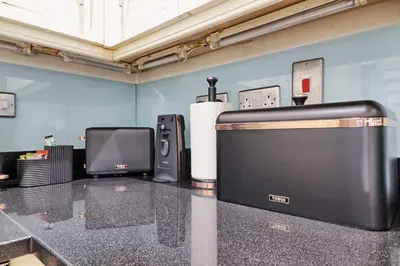 a counter top with a television and other appliances at LMV Property - Modern Luxury Family Home in Theydon Bois With London Skyline Views in Theydon Bois