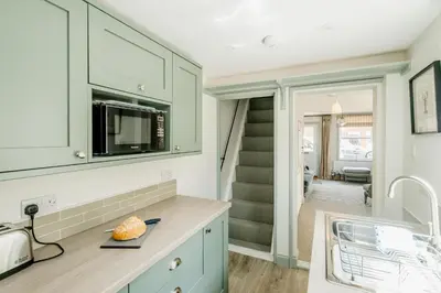 a kitchen with green cabinets and a counter with a microwave at Wigeon Cottage, Aldeburgh - Sleeps 4 - Adults only house in Aldeburgh