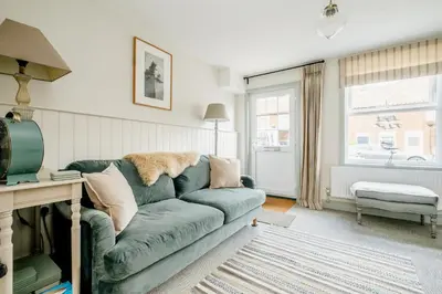 a living room with a green couch and a window at Wigeon Cottage, Aldeburgh - Sleeps 4 - Adults only house in Aldeburgh