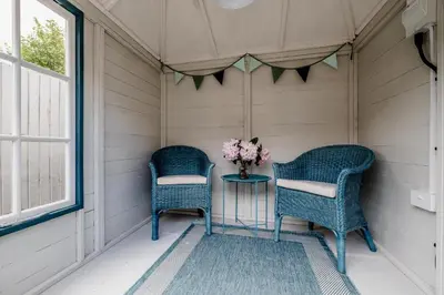 two chairs and a table with a vase of flowers at Wigeon Cottage, Aldeburgh - Sleeps 4 - Adults only house in Aldeburgh