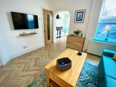 a living room with a blue couch and a tv at 2 Bedroom Apartment with Garden, Close to Beach in Southend-on-Sea