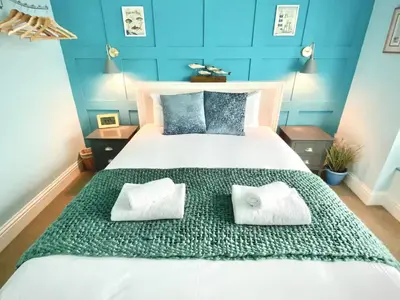 a bedroom with a large bed with two pillows on it at 2 Bedroom Apartment with Garden, Close to Beach in Southend-on-Sea