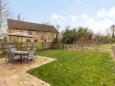 a table and chairs with an umbrella in a yard at Barrow Barn in Wicken