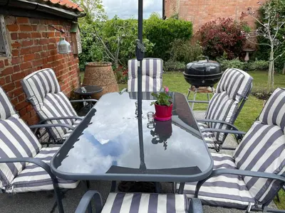 a glass table with a potted plant on a patio at Walnut Cottage in Sproughton