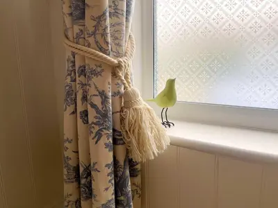 a window curtain with a bird on a window sill at Luxury 1 Bedroom Apartment in Southend w Parking in Southend-on-Sea